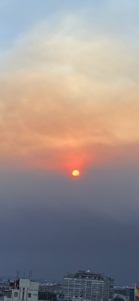 Solen slukes av røykskyen som henger over byen. 